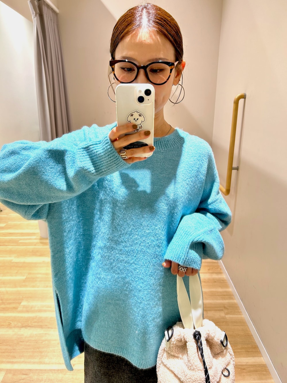 ブラック系のダウンジャケット/コート、ブルー系のニット/セーター、グレー系のスカートを着用したレディースの冬コーディネートの10枚目の写真