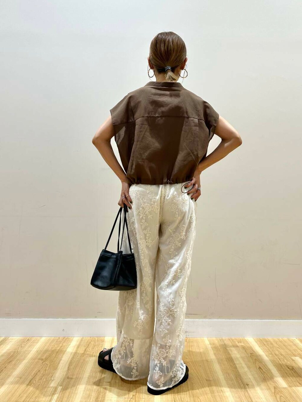 ホワイト系のその他パンツ、ブラック系のハンドバッグ、ブラック系のサンダルを着用したレディースの夏コーディネートの3枚目の写真