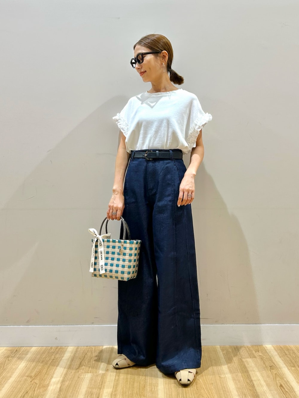ホワイト系のTシャツ/カットソー、ブルー系のデニムパンツ、グリーン系のショルダーバッグを着用したレディースの夏コーディネートの5枚目の写真