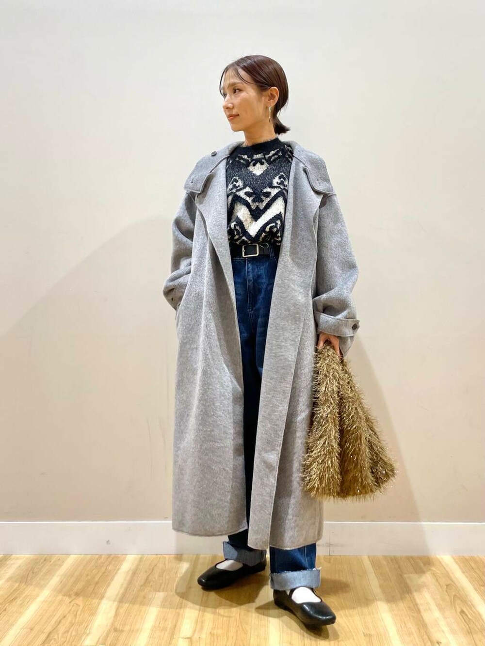 ブラック系のパンプス、ブルー系のデニムパンツ、グレー系のその他アウターを着用したレディースの冬コーディネートの2枚目の写真