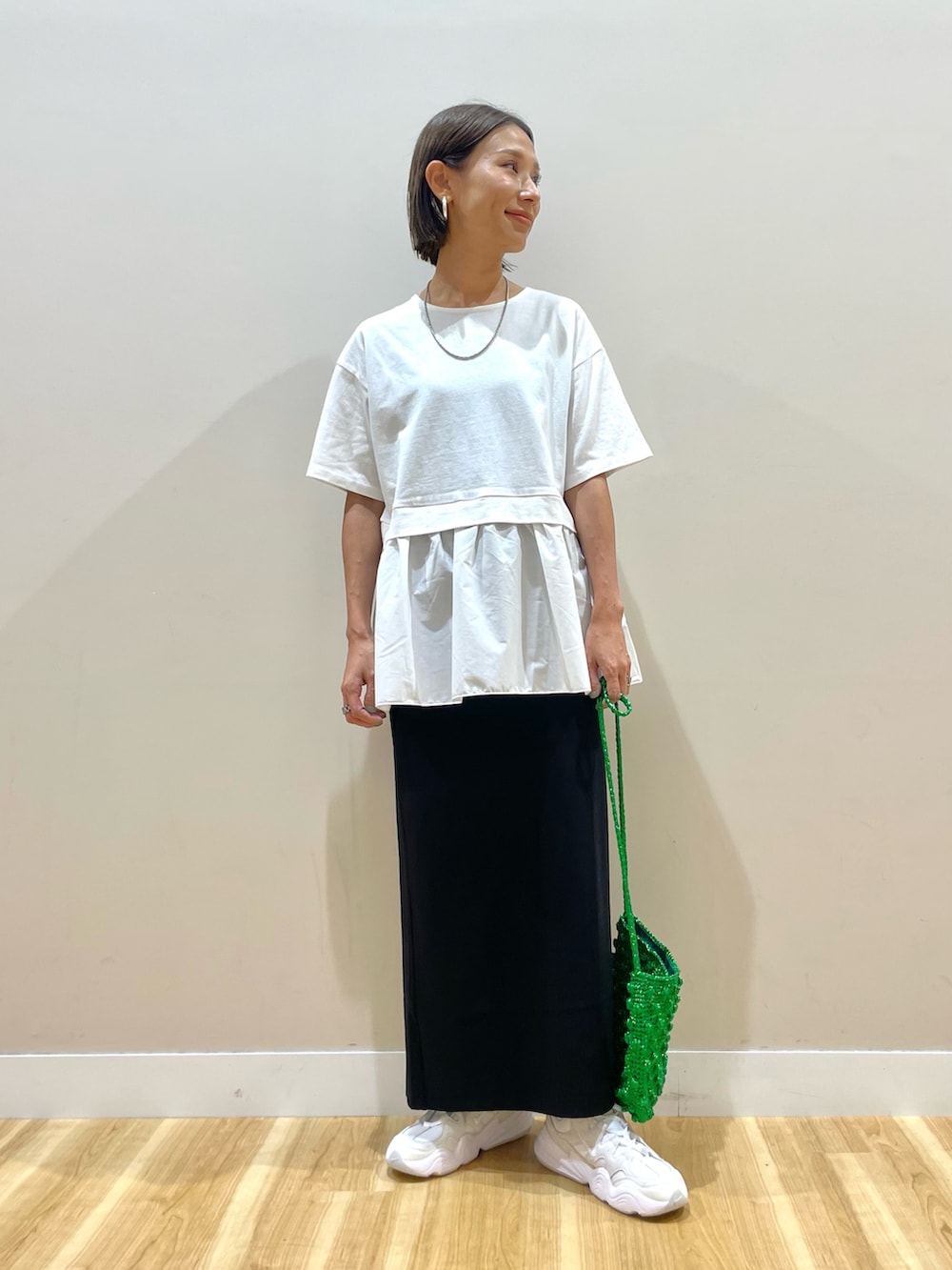 ブラック系のベスト、ホワイト系のTシャツ/カットソー、ブラック系のスカートを着用したレディースの秋コーディネートの6枚目の写真