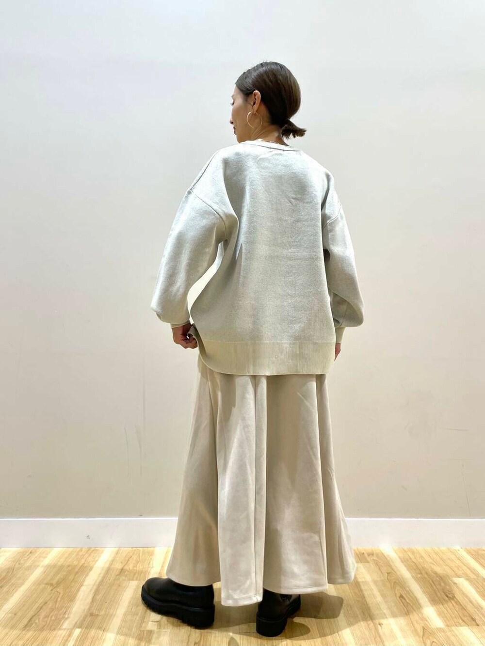 ブラック系のブーツ、ベージュ系のショルダーバッグ、ベージュ系のスカートを着用したレディースの秋コーディネートの8枚目の写真