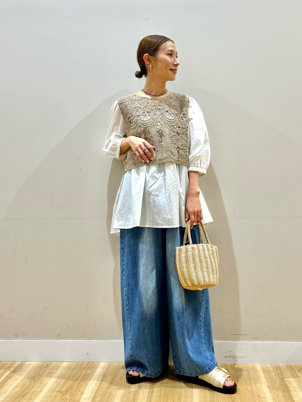 ベージュ系のシャツ/ブラウス、グレー系のハンドバッグ、ホワイト系のサンダルを着用したレディースの夏コーディネートの2枚目の写真