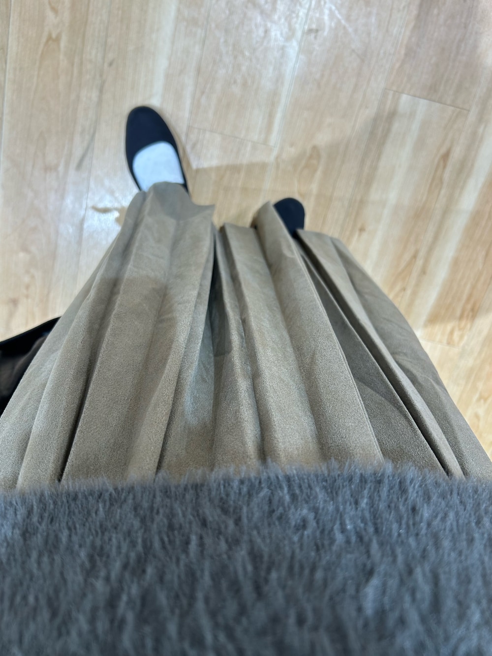 グレー系のニット/セーター、グリーン系のスカート、ブラック系のショルダーバッグを着用したレディースの秋コーディネートの6枚目の写真