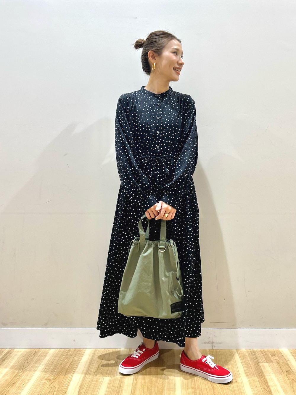 ホワイト系のマウンテンパーカー、ブラック系のワンピース、グリーン系のショルダーバッグを着用したレディースの春コーディネートの5枚目の写真