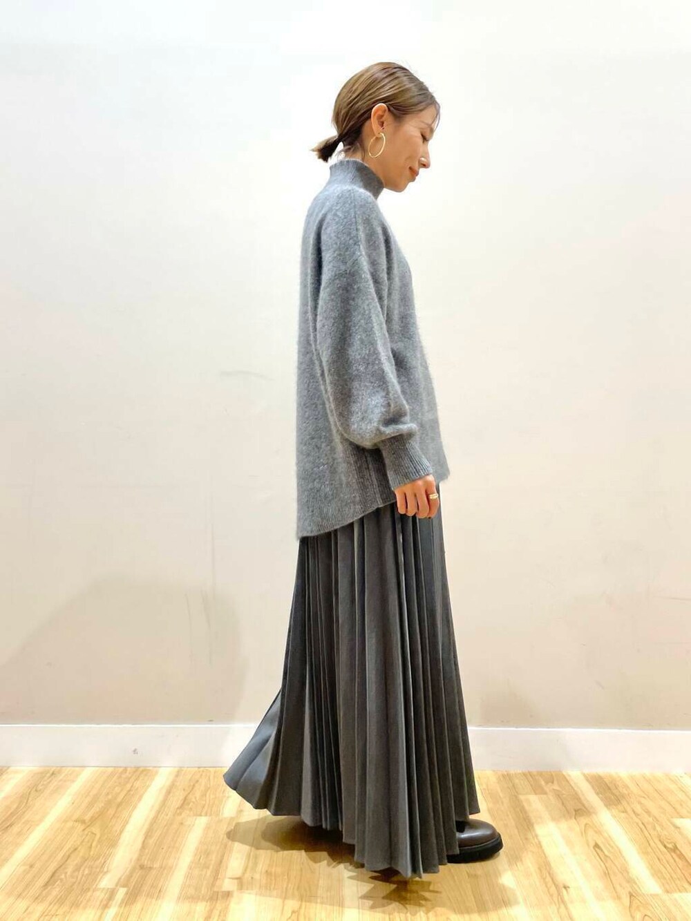 ブラウン系のブーツ、オレンジ系のショルダーバッグ、グレー系のスカートを着用したレディースの冬コーディネートの7枚目の写真