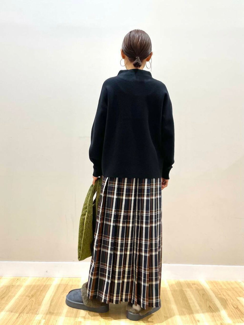 ゴールド系のトートバッグ、ブラック系のニット/セーター、ブルー系のスカートを着用したレディースの冬コーディネートの6枚目の写真