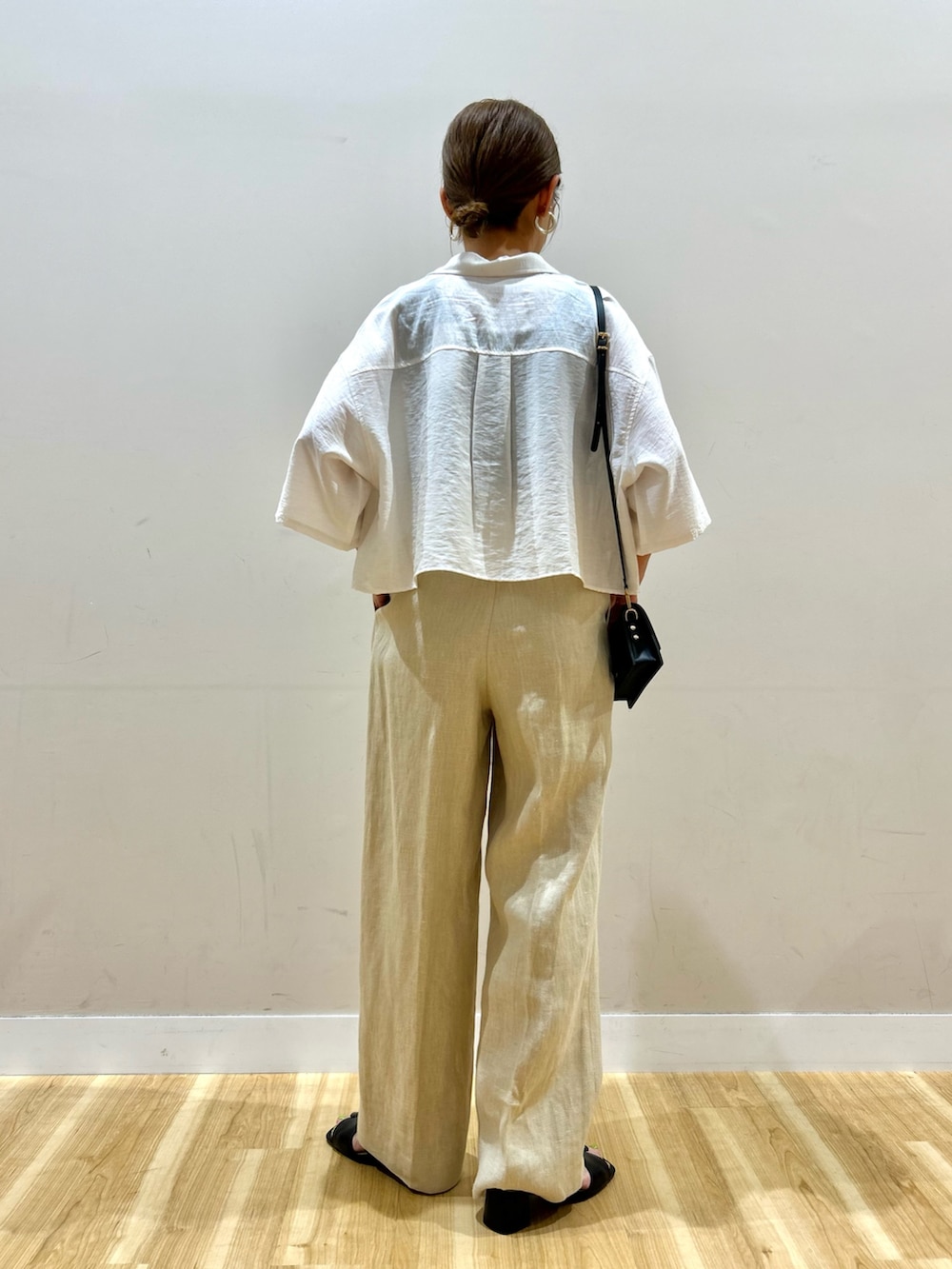 ホワイト系のシャツ/ブラウス、ベージュ系のその他パンツ、ブラック系のショルダーバッグを着用したレディースの夏コーディネートの3枚目の写真