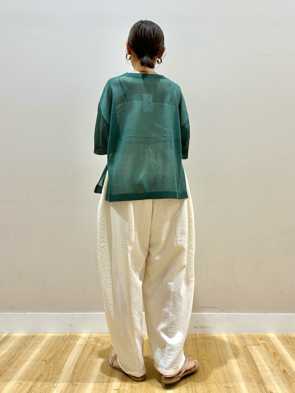 グリーン系のニット/セーター、ホワイト系のその他パンツを着用したレディースの夏コーディネートの4枚目の写真