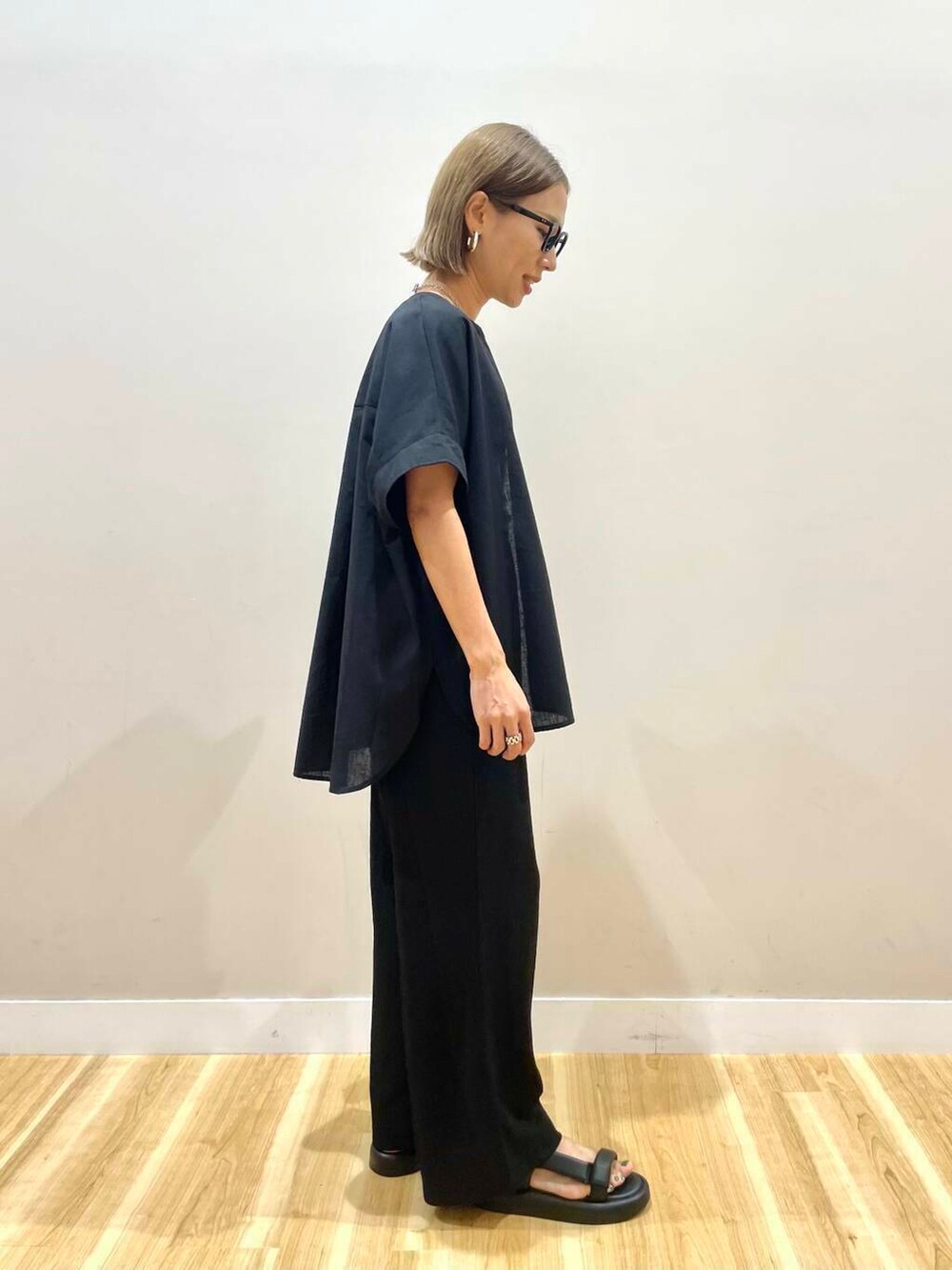 グリーン系のタンクトップ、グレー系のショルダーバッグ、ブラック系のサンダルを着用したレディースの夏コーディネートの2枚目の写真