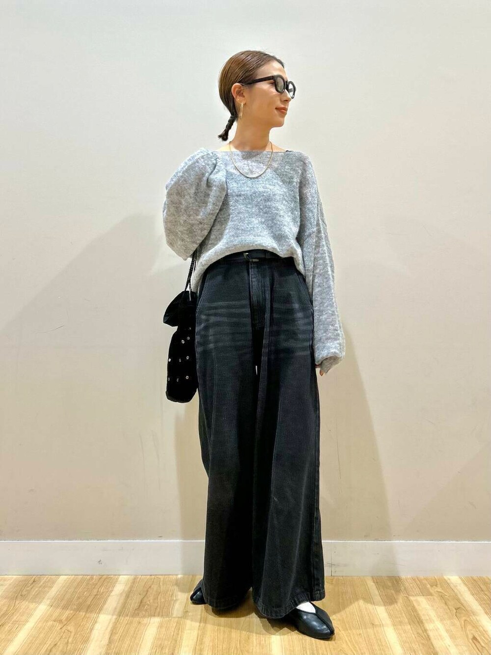 ブラック系のショルダーバッグ、ブラック系のデニムパンツ、グレー系のニット/セーターを着用したレディースの春コーディネートの4枚目の写真