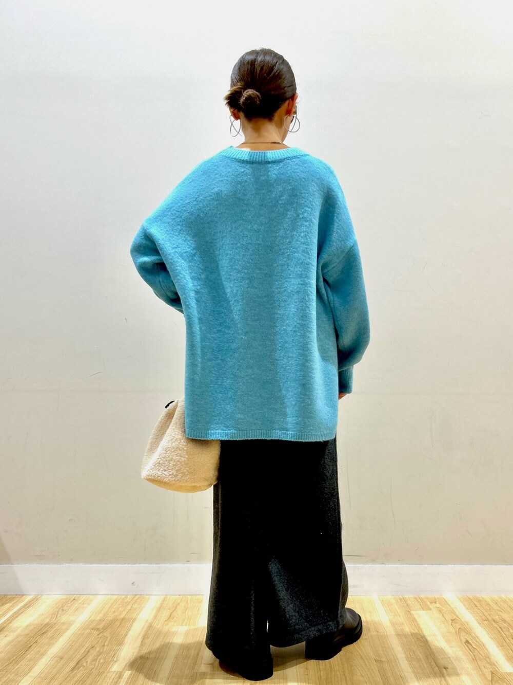 ブラック系のダウンジャケット/コート、ブルー系のニット/セーター、グレー系のスカートを着用したレディースの冬コーディネートの8枚目の写真