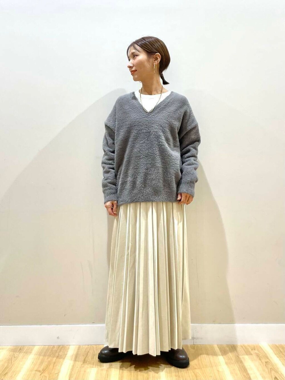 ベージュ系のスカート、ブラック系のブーツ、グレー系のダウンジャケット/コートを着用したレディースの冬コーディネートの7枚目の写真