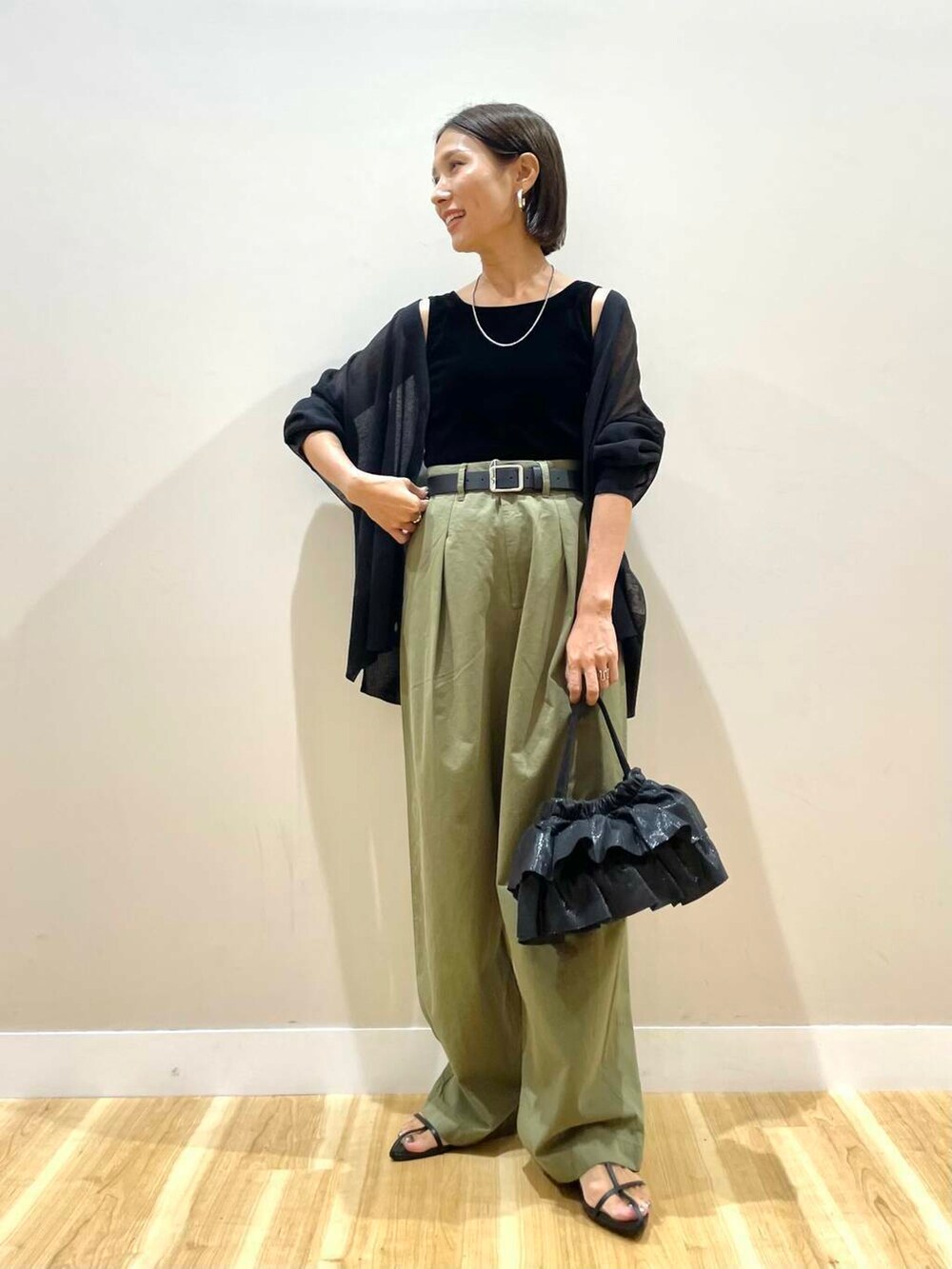 ブラック系のショルダーバッグ、ブラック系のカーディガン/ボレロ、ブラック系のタンクトップを着用したレディースの秋コーディネートの4枚目の写真