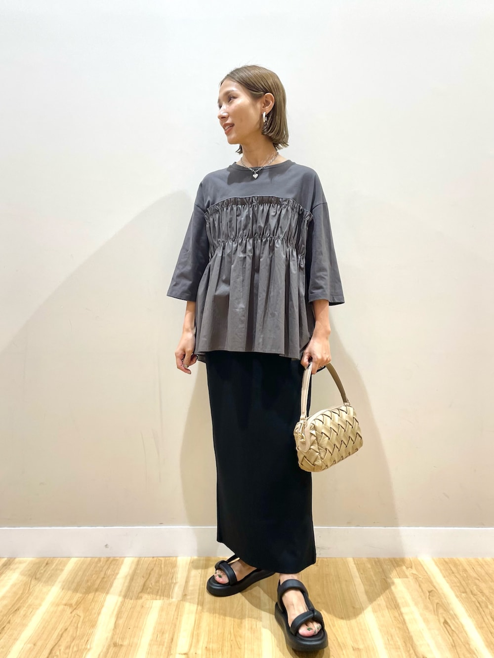 グレー系のTシャツ/カットソー、ブラック系のスカート、ブルー系のデニムパンツを着用したレディースの夏コーディネートの4枚目の写真