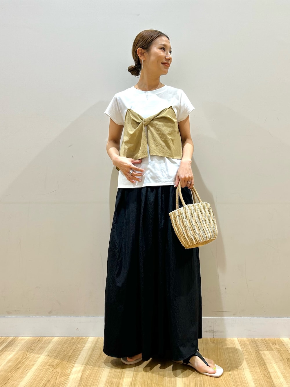 ベージュ系のTシャツ/カットソー、ブラック系のスカート、グレー系のハンドバッグを着用したレディースの夏コーディネートの5枚目の写真