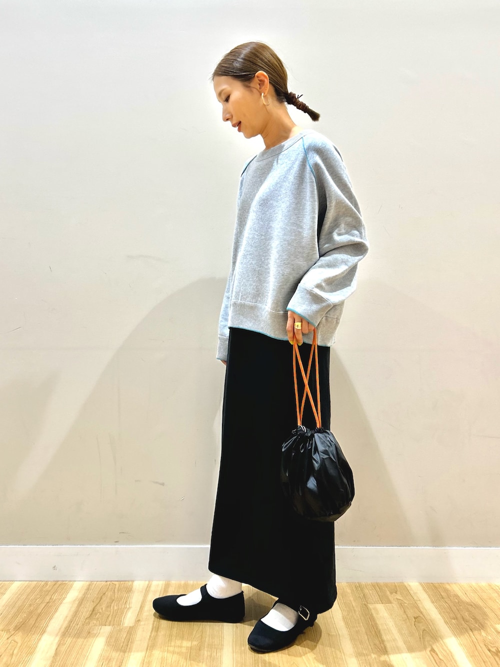 ベージュ系のダウンジャケット/コート、グレー系のニット/セーター、ブラック系のスカートを着用したレディースの秋コーディネートの5枚目の写真