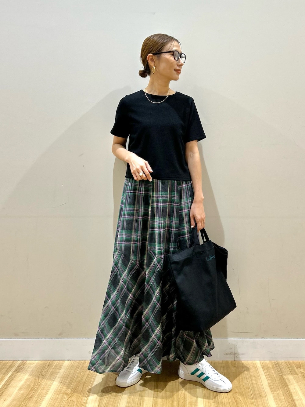 ブラック系のTシャツ/カットソー、グリーン系のスカート、ホワイト系のスニーカーを着用したレディースの夏コーディネートの5枚目の写真