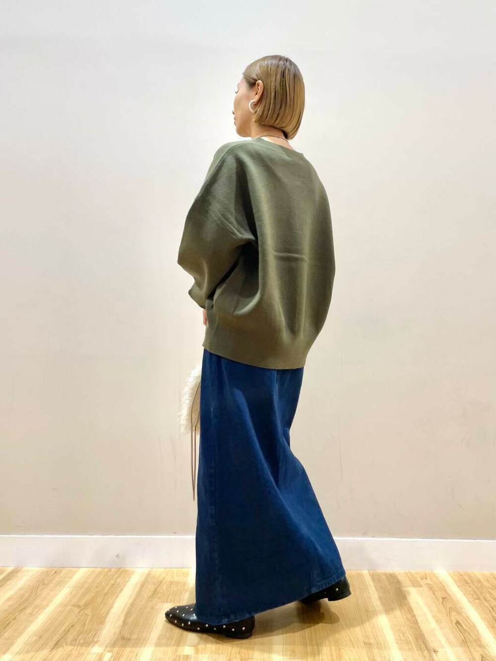 ベージュ系のショルダーバッグ、ブラック系のパンプス、ブルー系のスカートを着用したレディースの秋コーディネートの5枚目の写真