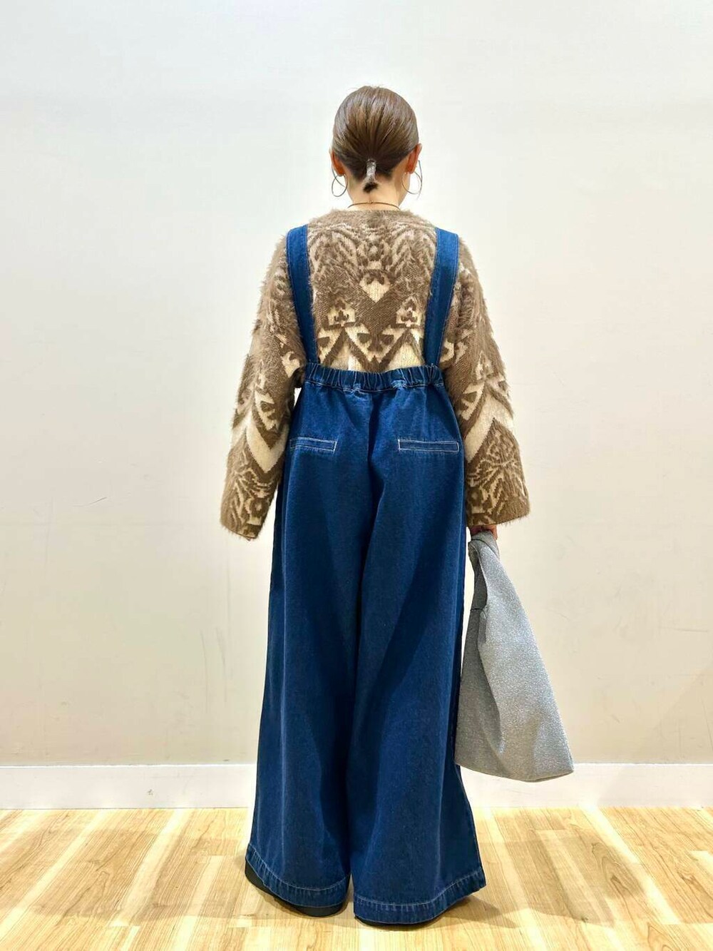 シルバー系のトートバッグ、ブラック系のその他シューズ、ブラウン系のニット/セーターを着用したレディースの冬コーディネートの2枚目の写真