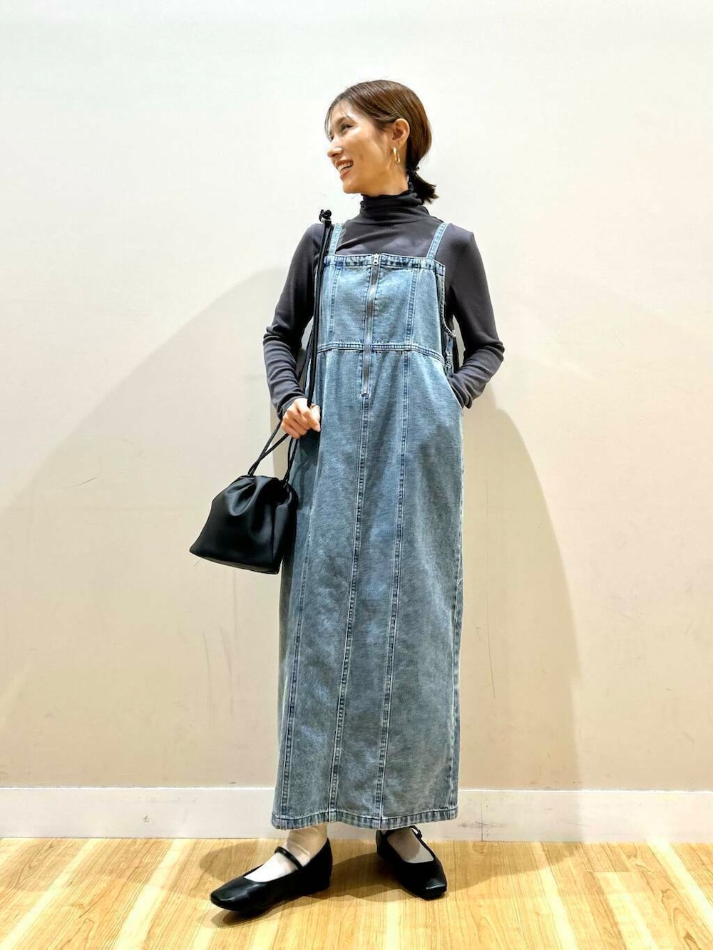 ブルー系のワンピース、ブラック系のパンプス、グレー系のTシャツ/カットソーを着用したレディースの春コーディネートの2枚目の写真