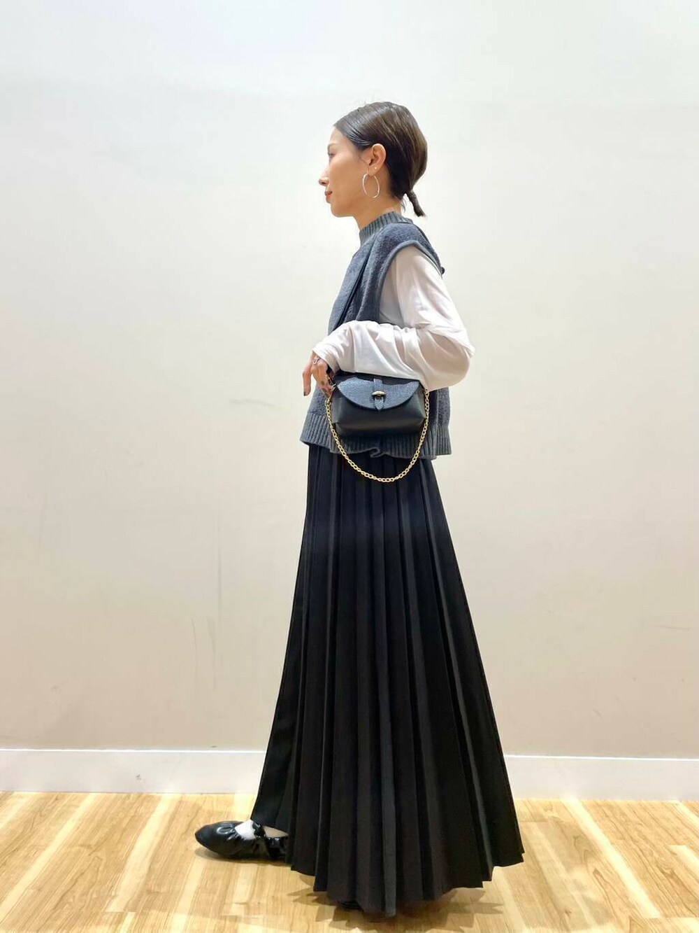 ブラック系のショルダーバッグ、ホワイト系のTシャツ/カットソー、ブラック系のバレエシューズを着用したレディースの秋コーディネートの5枚目の写真