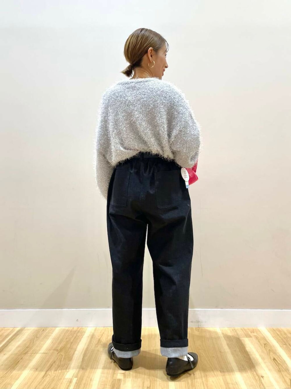 ブラック系のパンプス、ブラック系のハンドバッグ、ブラック系のデニムパンツを着用したレディースの冬コーディネートの4枚目の写真