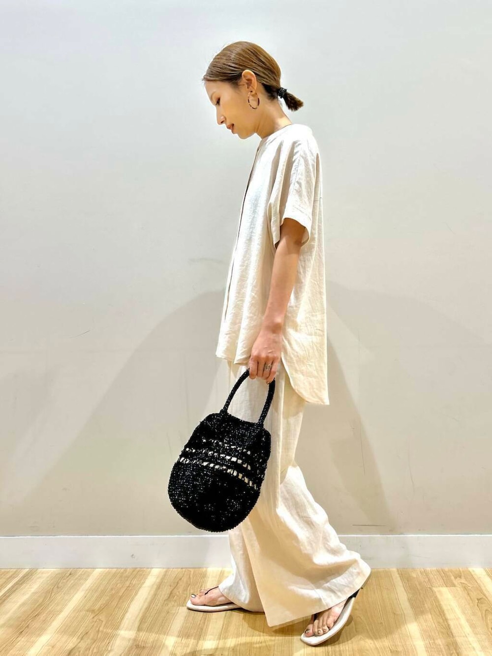 ベージュ系のその他パンツ、ベージュ系のシャツ/ブラウス、ブラック系のショルダーバッグを着用したレディースの夏コーディネートの2枚目の写真