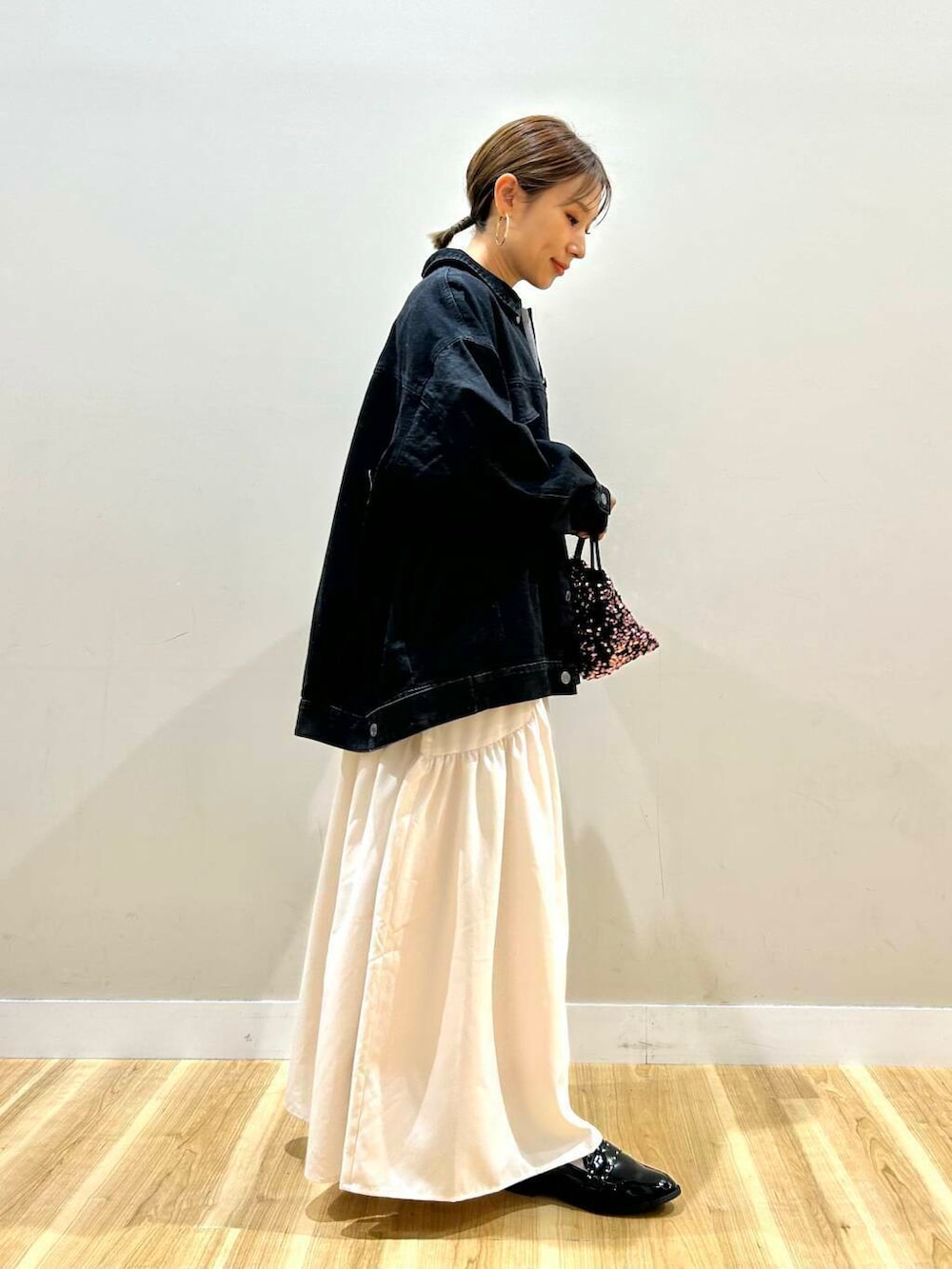 ブラック系のローファー、グレー系のワンピース、ピンク系のショルダーバッグを着用したレディースの冬コーディネートの2枚目の写真