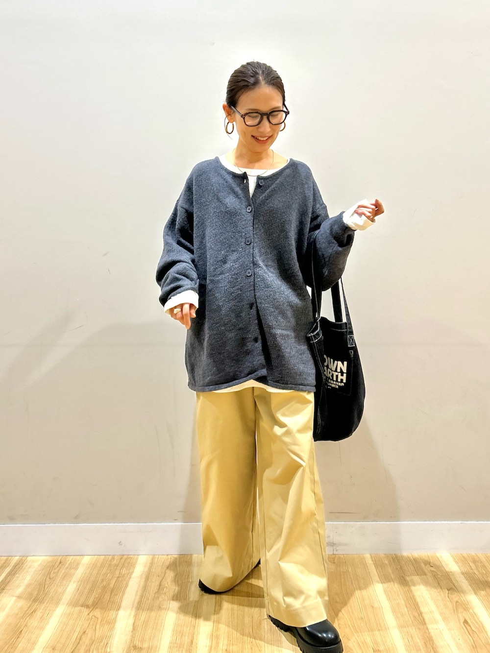 グレー系のニット/セーター、ホワイト系のシャツ/ブラウス、ベージュ系のその他パンツを着用したレディースの秋コーディネートの6枚目の写真