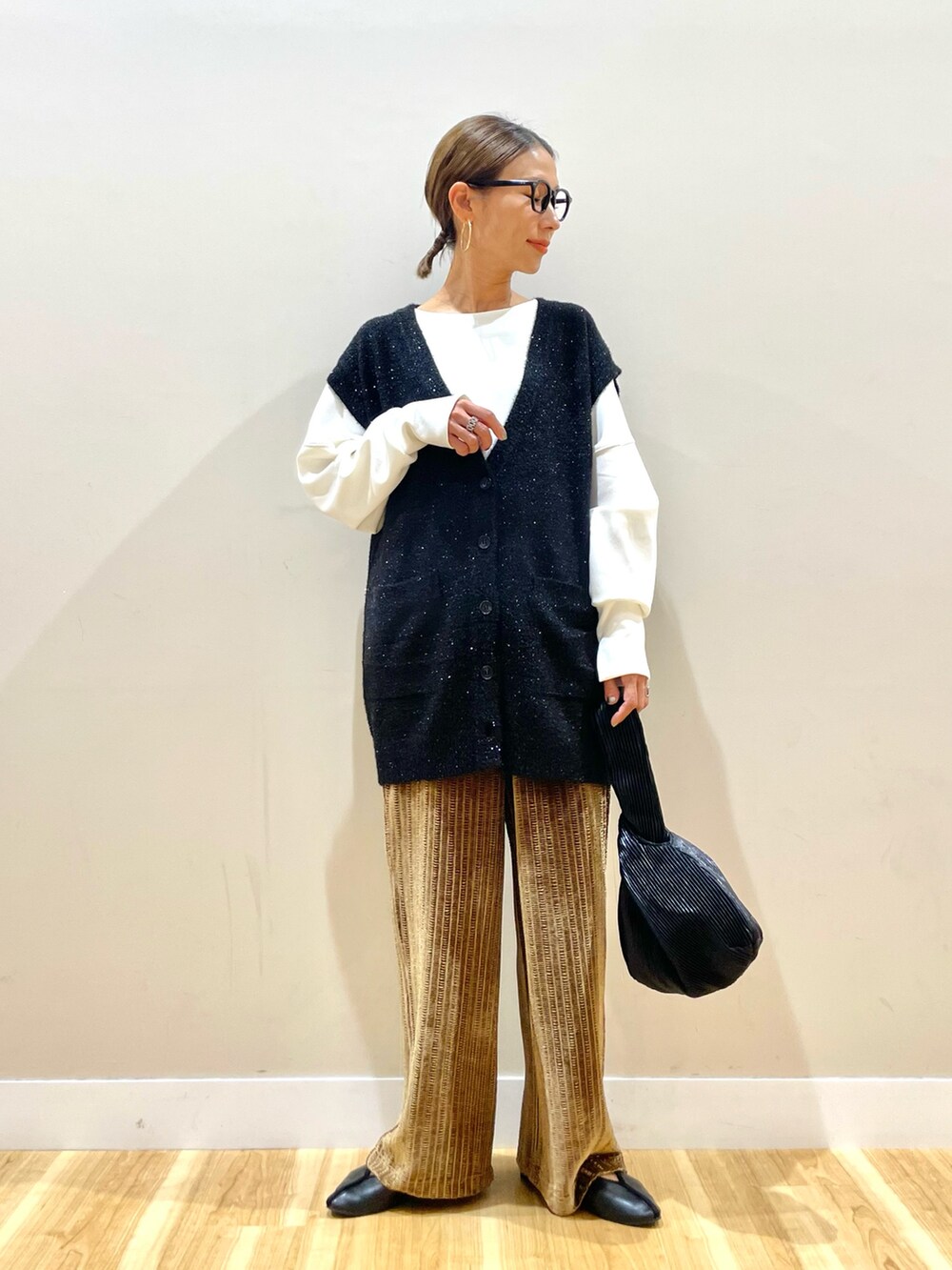 ブラック系のベスト、ホワイト系のTシャツ/カットソー、ブラウン系のその他パンツを着用したレディースの秋コーディネートの2枚目の写真