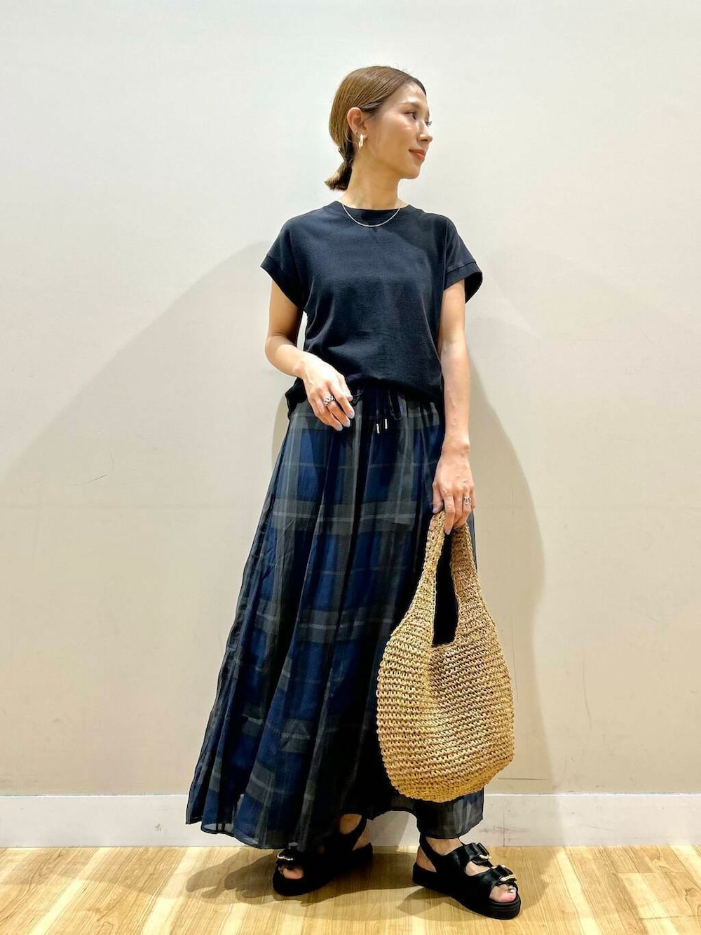 ブラック系のサンダル、イエロー系のトートバッグ、ブルー系のスカートを着用したレディースの夏コーディネートの5枚目の写真