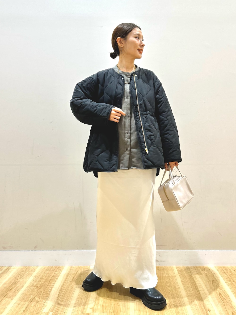 ブラック系のブルゾン、ホワイト系のスカート、グレー系のボストンバッグを着用したレディースの冬コーディネートの7枚目の写真