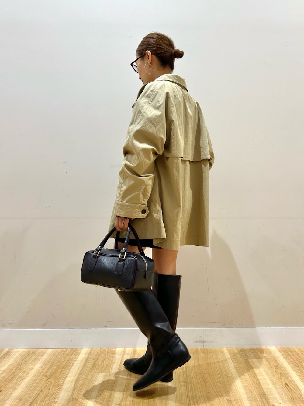 ベージュ系のその他アウター、レッド系のシャツ/ブラウス、ブラック系のハンドバッグを着用したレディースの秋コーディネートの4枚目の写真