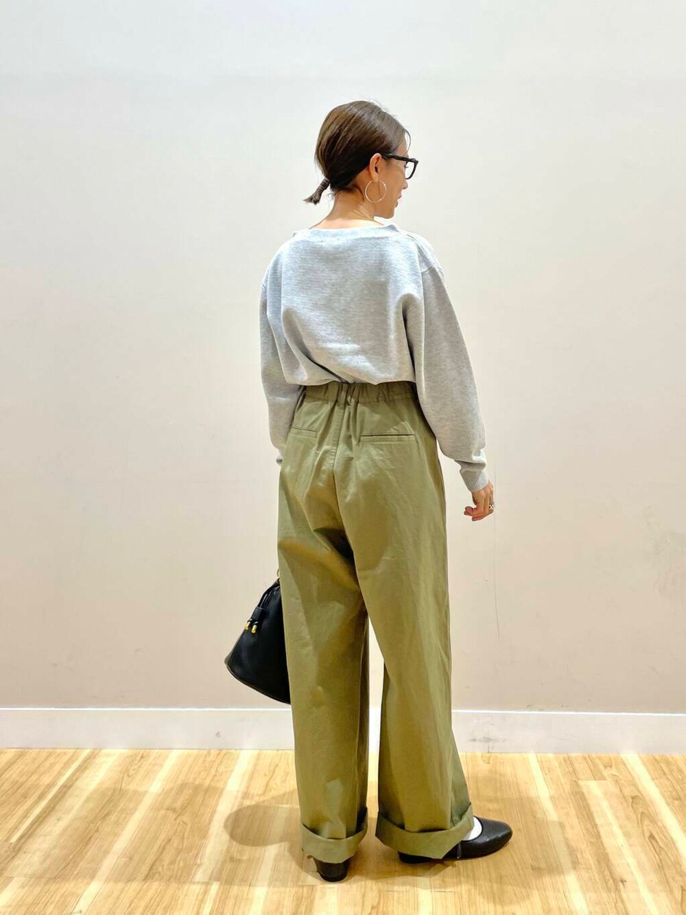 ブラック系のパンプス、ブラック系のショルダーバッグ、グレー系のニット/セーターを着用したレディースの秋コーディネートの3枚目の写真