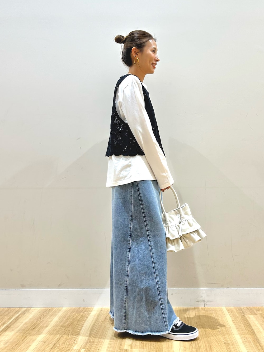 グリーン系のブルゾン、ブラック系のTシャツ/カットソー、ブルー系のスカートを着用したレディースの春コーディネートの5枚目の写真