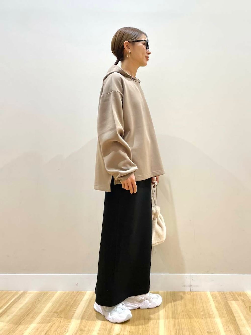 ホワイト系のスニーカー、ホワイト系のショルダーバッグ、ブラウン系のワンピースを着用したレディースの冬コーディネートの8枚目の写真