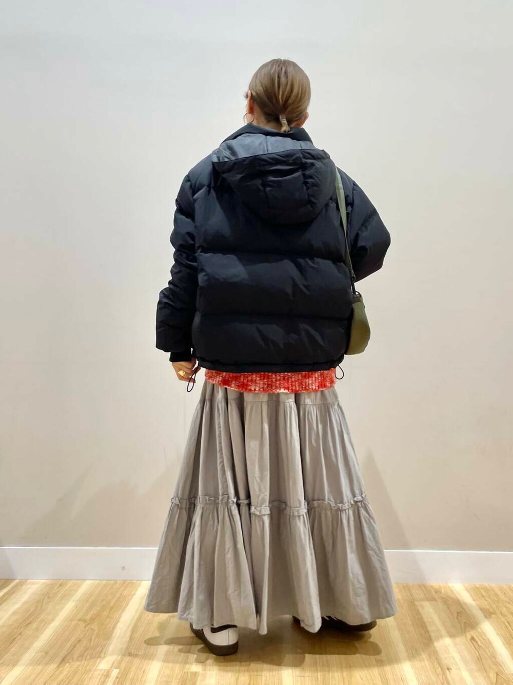 ブラック系のダウンジャケット/コート、グリーン系のショルダーバッグ、レッド系のニット/セーターを着用したレディースの冬コーディネートの3枚目の写真