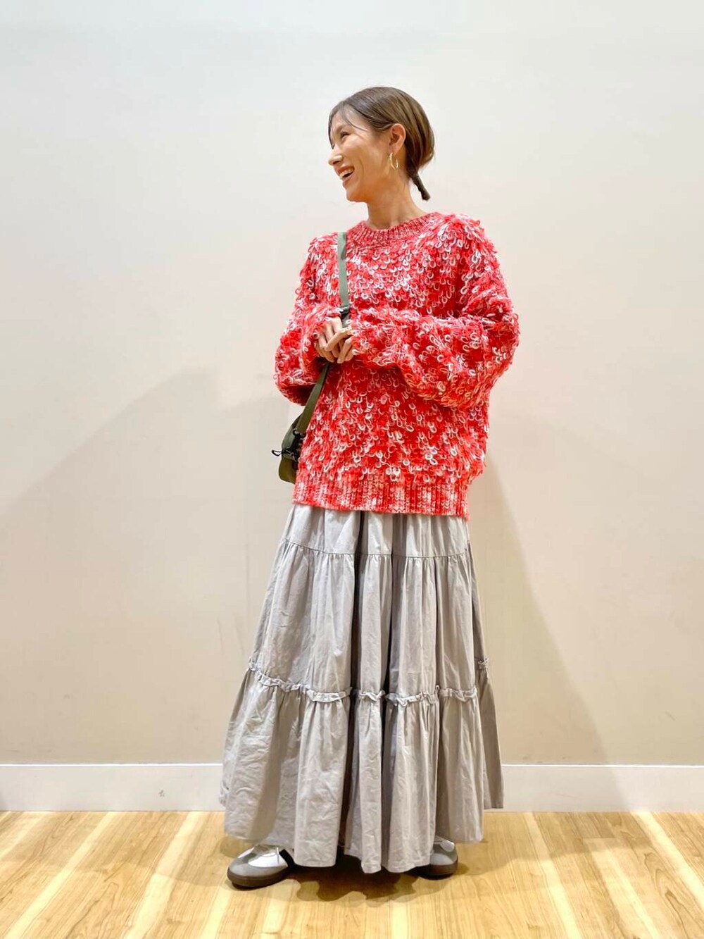 ブラック系のダウンジャケット/コート、グリーン系のショルダーバッグ、レッド系のニット/セーターを着用したレディースの冬コーディネートの5枚目の写真