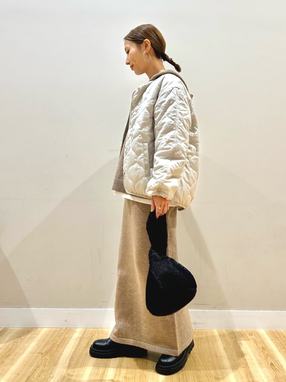 ベージュ系のニット/セーター、ホワイト系のTシャツ/カットソー、ホワイト系のダウンジャケット/コートを着用したレディースの秋コーディネートの2枚目の写真