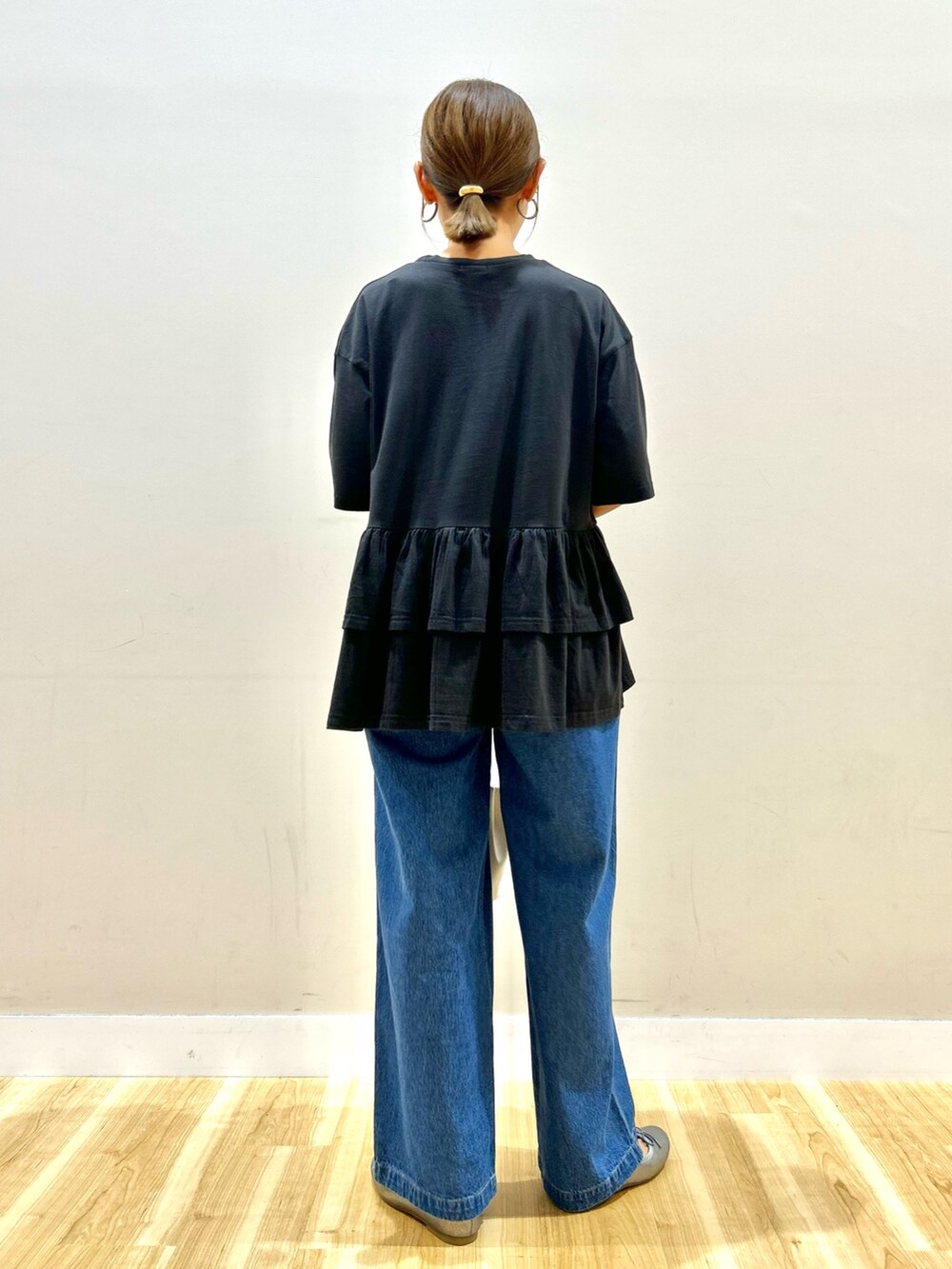 ブラック系のTシャツ/カットソー、ブルー系のデニムパンツ、ゴールド系のショルダーバッグを着用したレディースの秋コーディネートの3枚目の写真