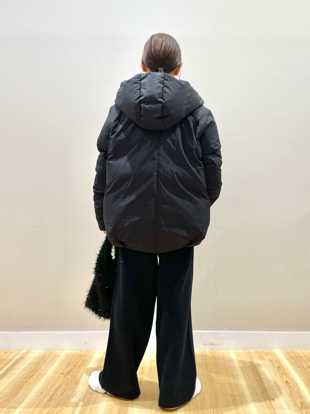 ブラック系のダウンジャケット/コート、ベージュ系のTシャツ/カットソー、ブラック系のその他パンツを着用したレディースの冬コーディネートの4枚目の写真