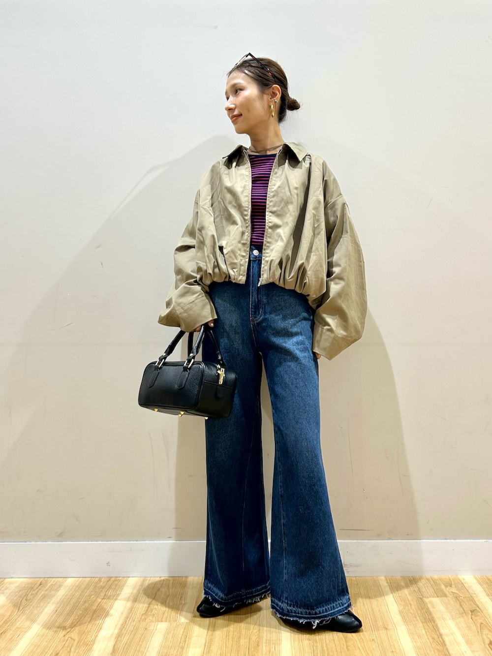 ベージュ系のブルゾン、ブルー系のTシャツ/カットソー、ブルー系のデニムパンツを着用したレディースの秋コーディネートの2枚目の写真