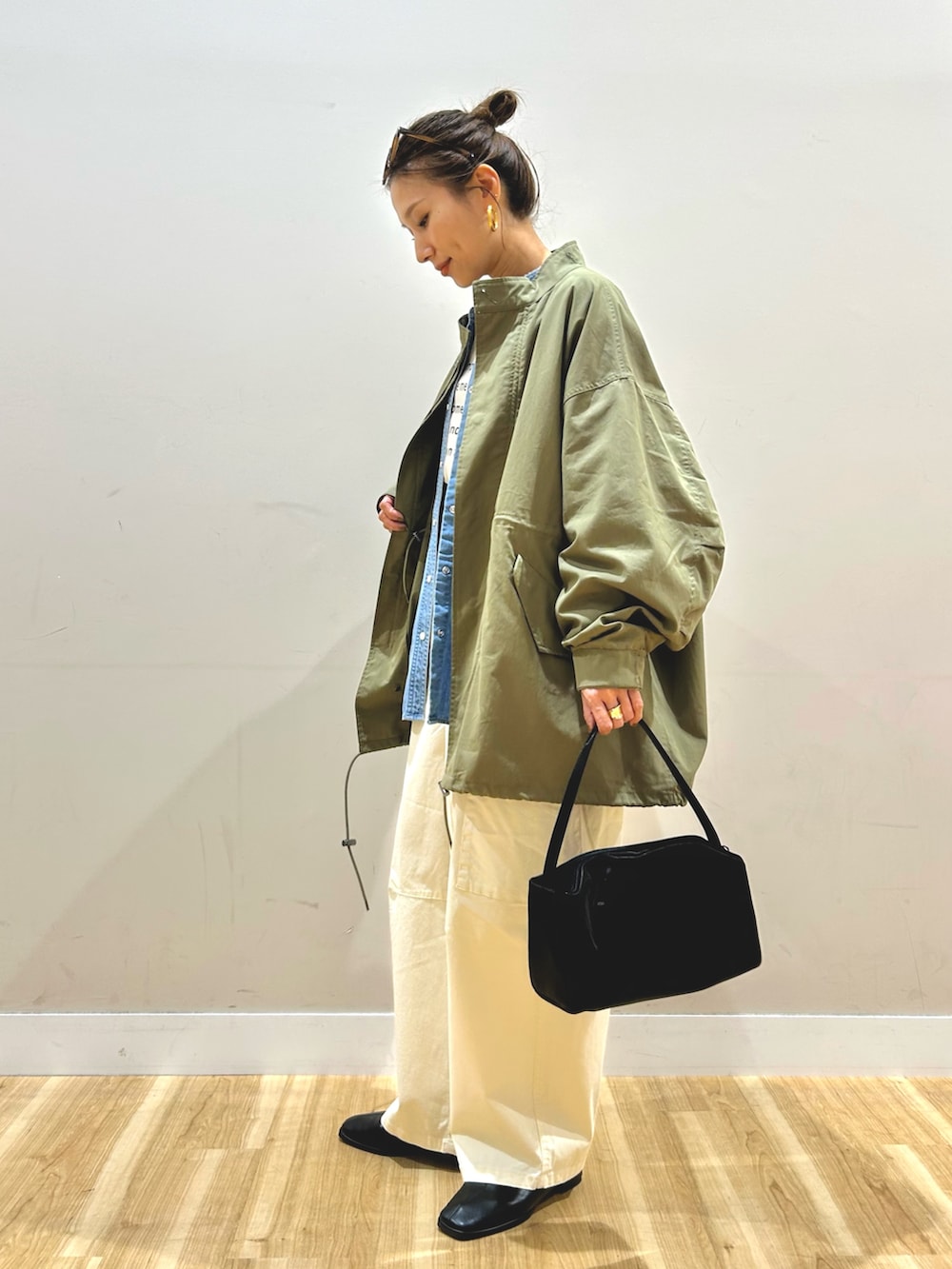 グリーン系のモッズコート、ブルー系のシャツ/ブラウス、ベージュ系のTシャツ/カットソーを着用したレディースの春コーディネートの3枚目の写真