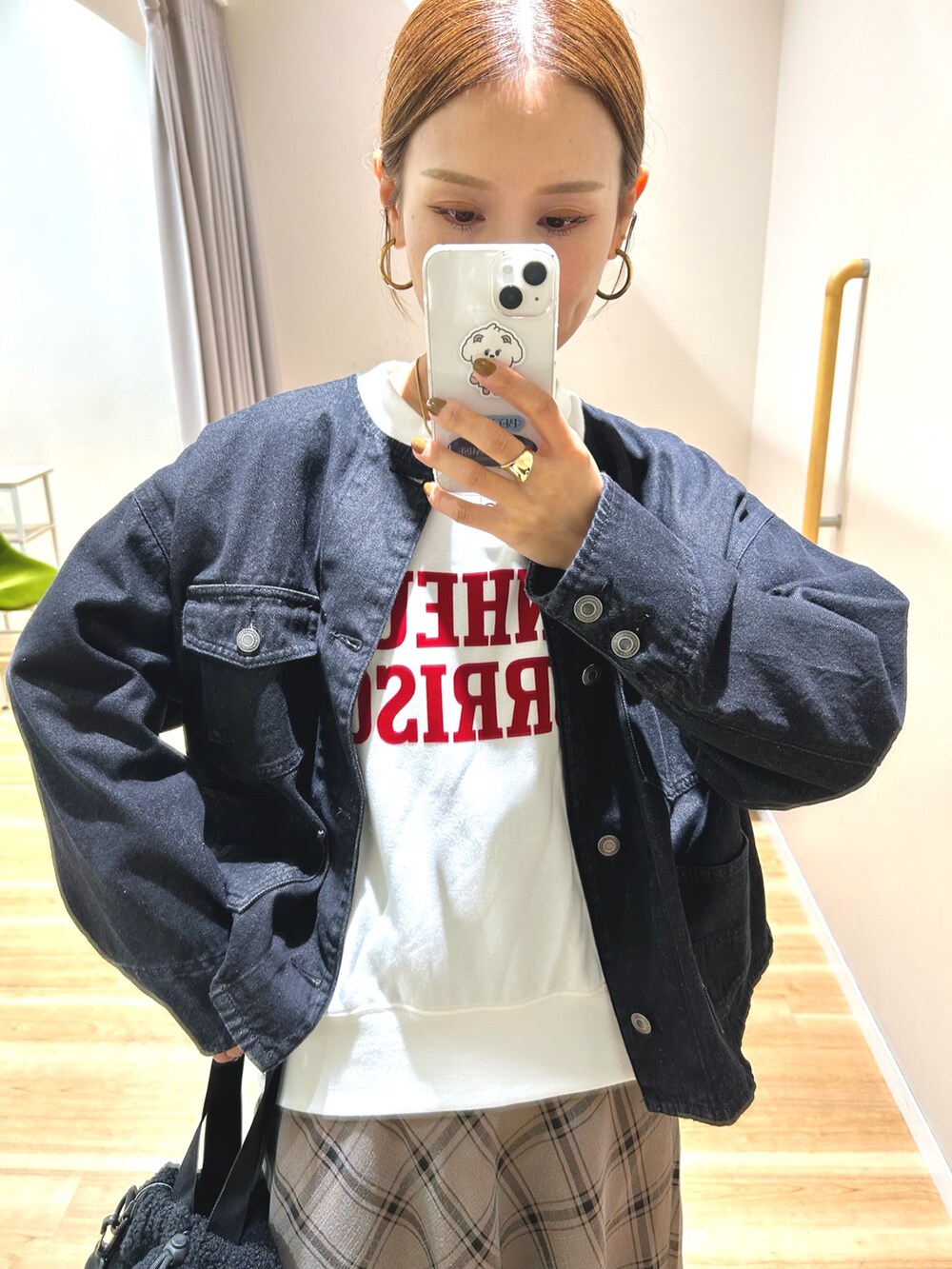 ブラック系のデニムジャケット、ホワイト系のスウェット、ブラウン系のスカートを着用したレディースの秋コーディネートの7枚目の写真