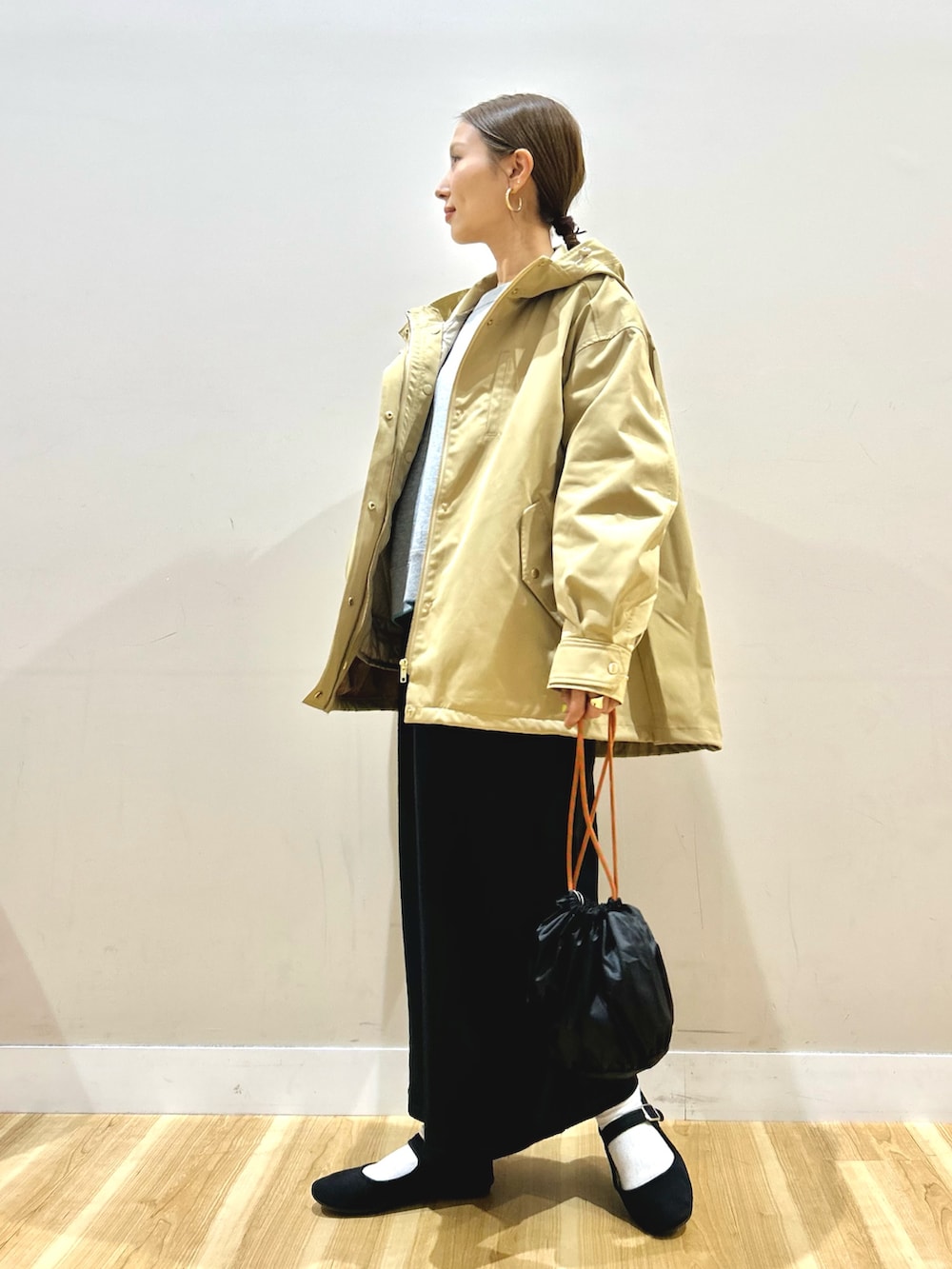 ベージュ系のダウンジャケット/コート、グレー系のニット/セーター、ブラック系のスカートを着用したレディースの秋コーディネートの2枚目の写真