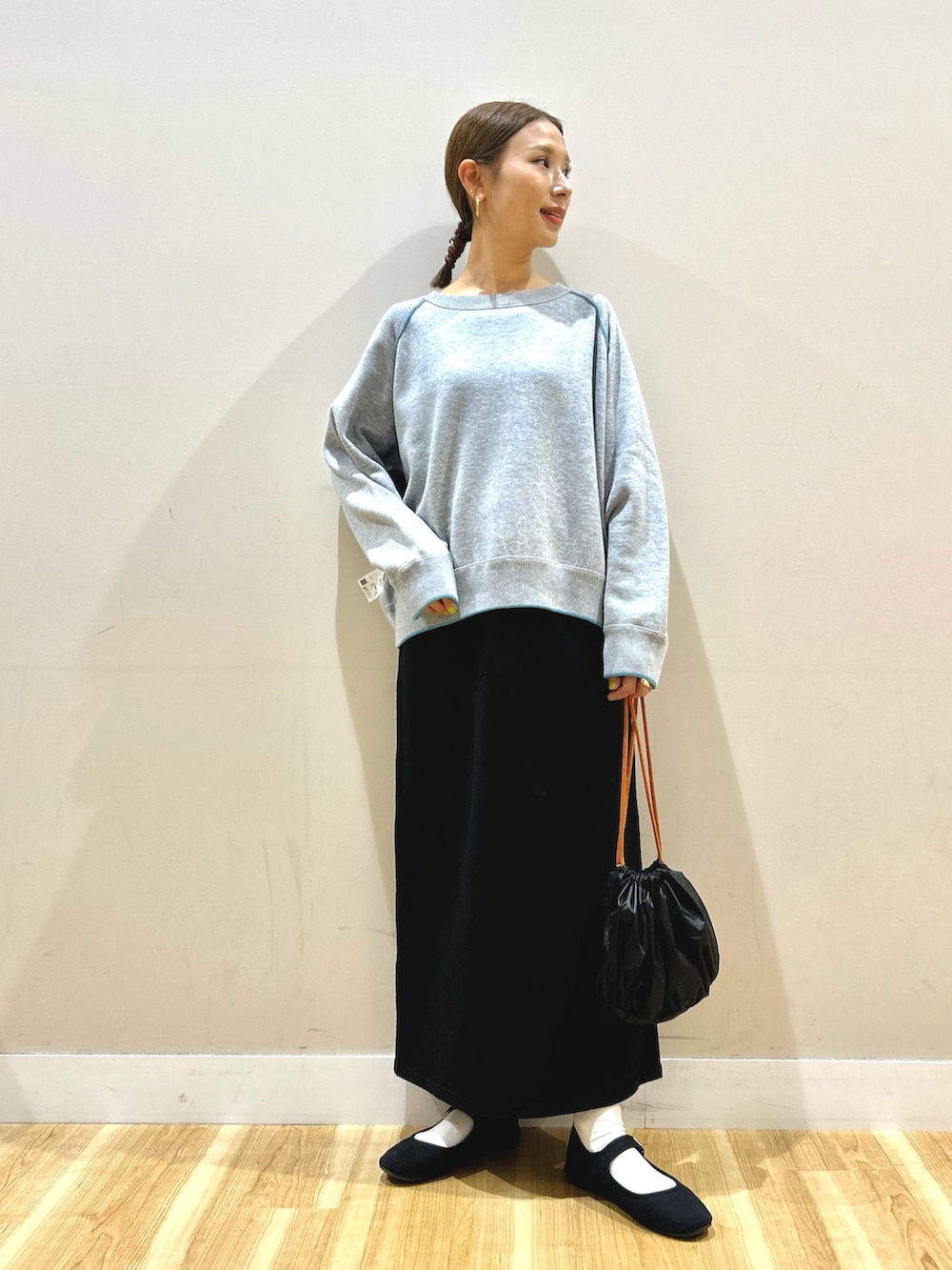 ベージュ系のダウンジャケット/コート、グレー系のニット/セーター、ブラック系のスカートを着用したレディースの秋コーディネートの4枚目の写真