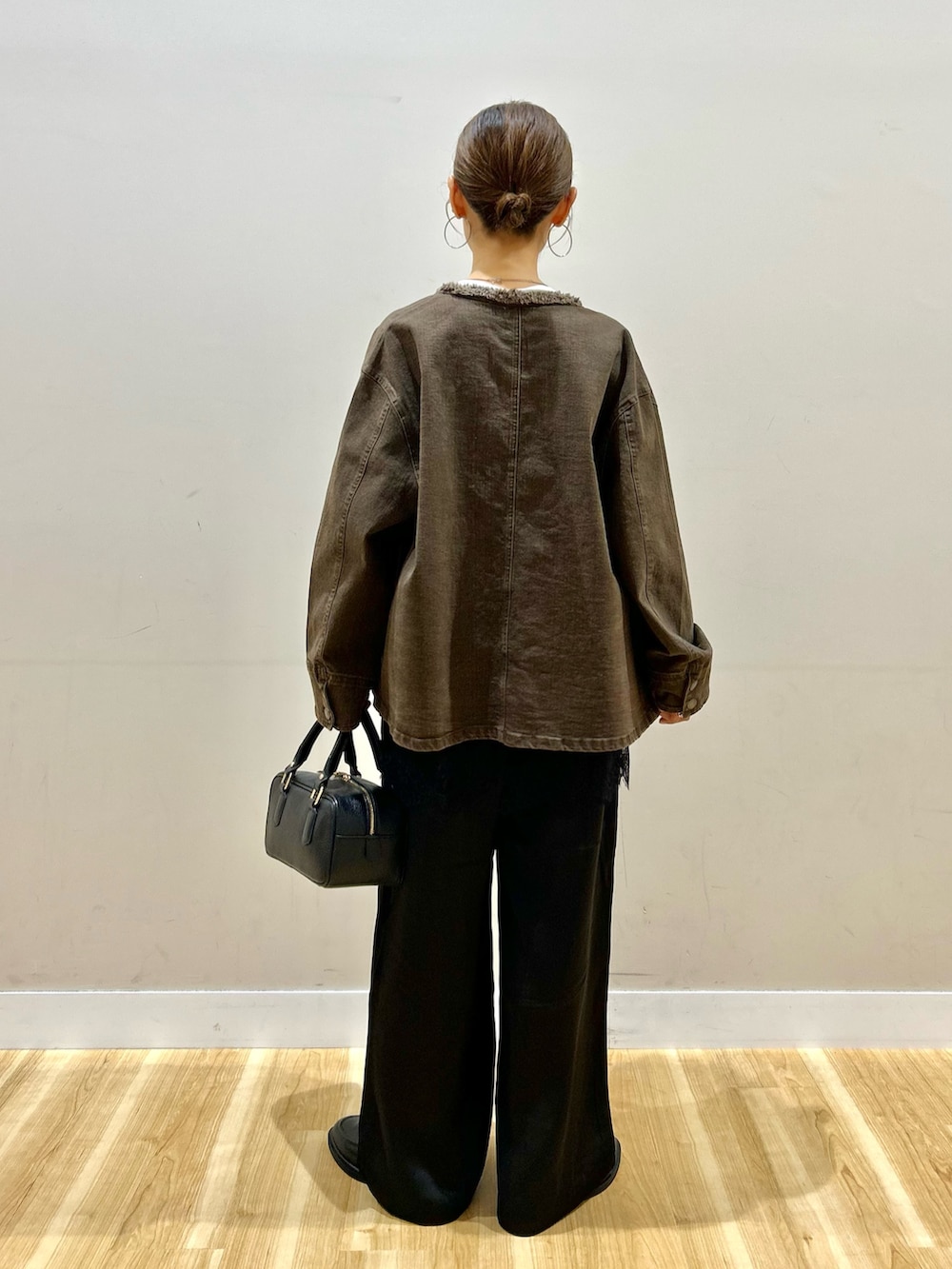 ブラウン系のデニムジャケット、ホワイト系のTシャツ/カットソー、ブラック系のその他パンツを着用したレディースの秋コーディネートの3枚目の写真