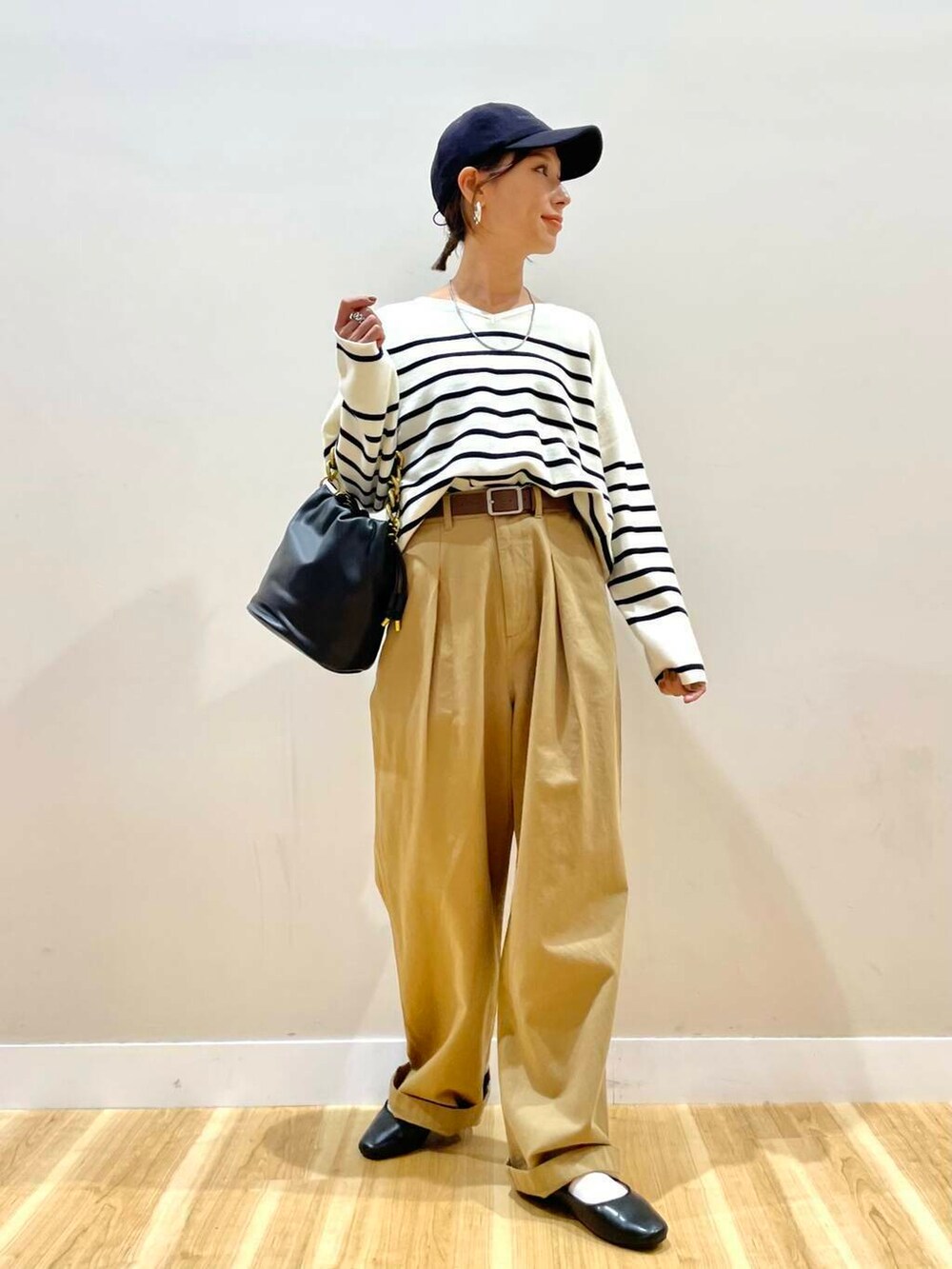 ブラック系のパンプス、ブラック系のショルダーバッグ、ブラック系のニット/セーターを着用したレディースの秋コーディネートの2枚目の写真