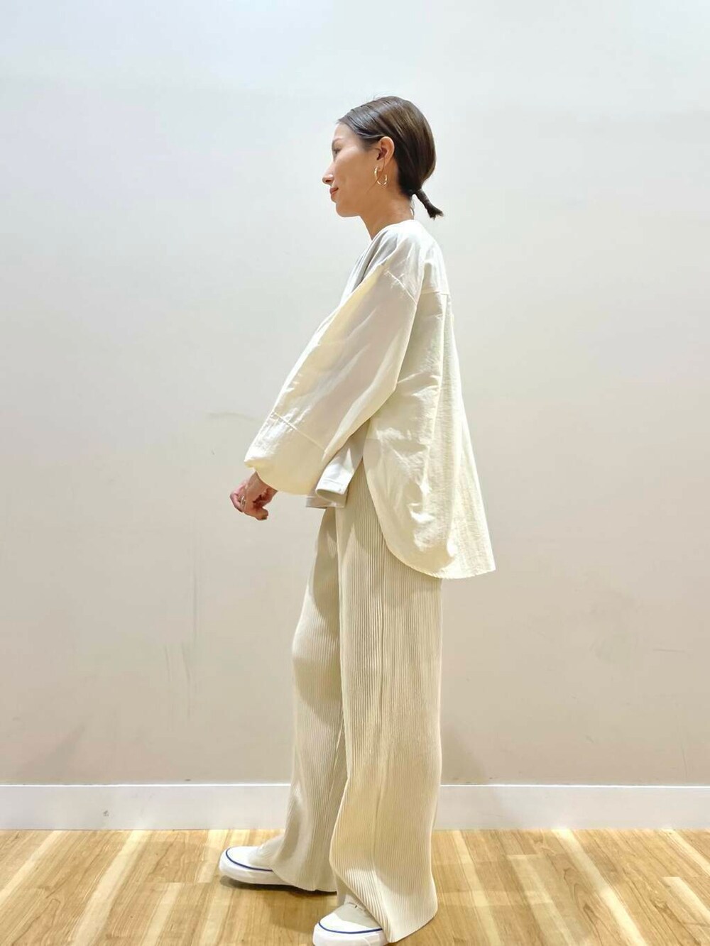 ホワイト系のスニーカー、ホワイト系のその他パンツ、イエロー系のハンドバッグを着用したレディースの秋コーディネートの4枚目の写真